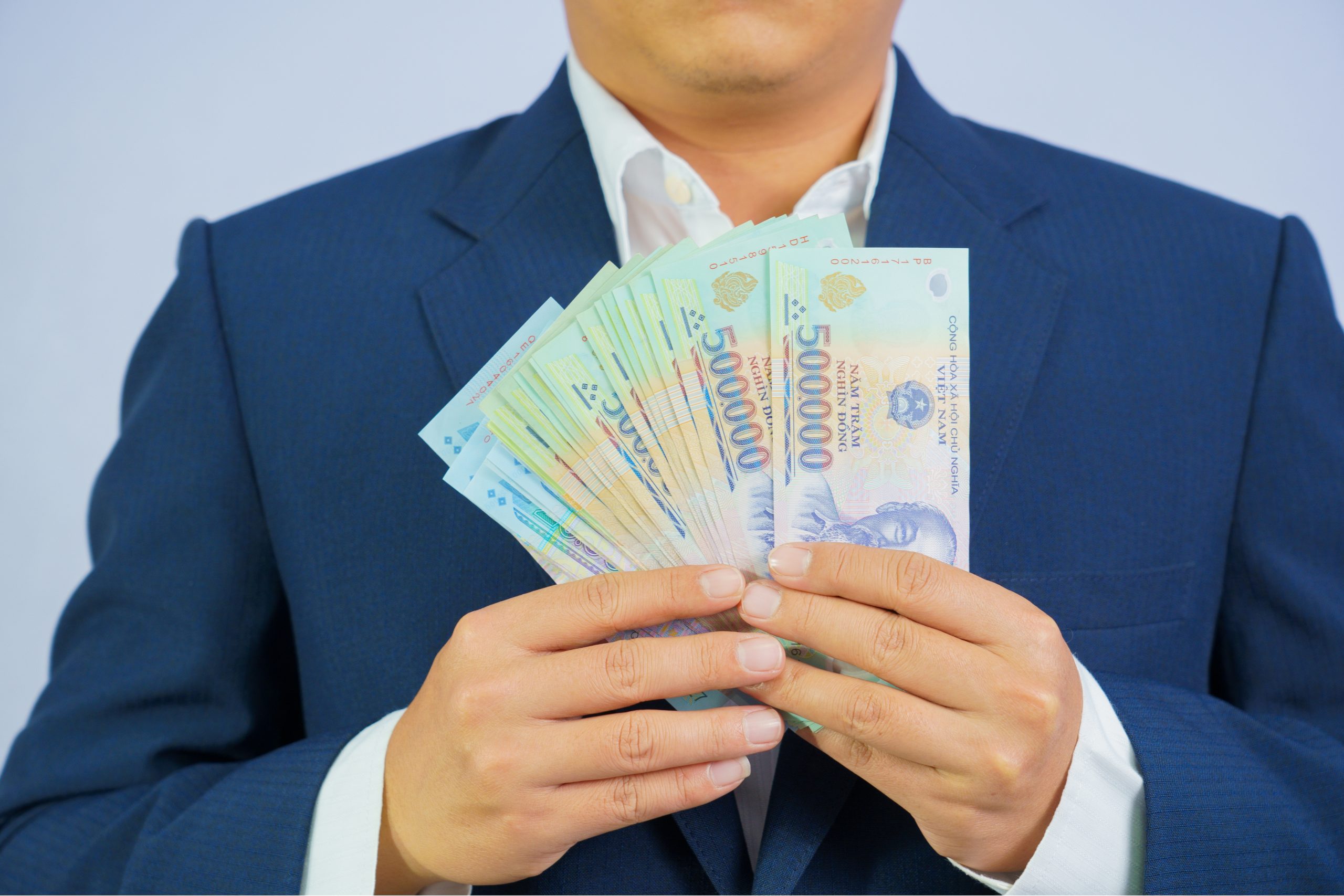 Money in Vietnam hold on hand business man wearing a blue suit (Socialist Republic Of Vietnam)